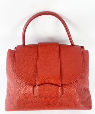 a red leather handbag with a bow on the handle