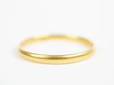gros plan d'une bague en or sur une surface blanche