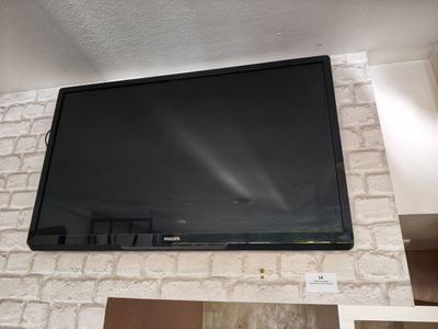 une télévision à écran plat fixée au mur au-dessus d'une cheminée