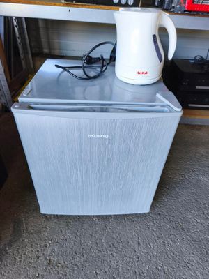 une cafetière posée sur un petit réfrigérateur