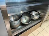 three metal bowls sitting on a shelf in a kitchen