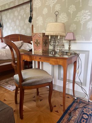 une chambre avec un lit et un bureau sur lequel se trouve une lampe