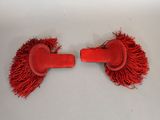pair of red hair clips with fringes on them on a white surface