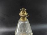 an antique brass and glass oil lamp on a black background