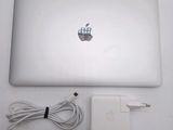 an apple laptop computer sitting on top of a table next to a charger