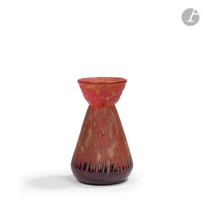 un vase rouge posé sur une surface blanche