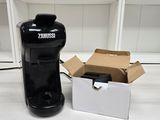 a black coffee maker and a box on a table