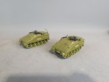 two green toy tanks sitting on a white surface