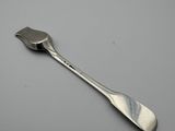 silver spoon on a gray surface with a white background