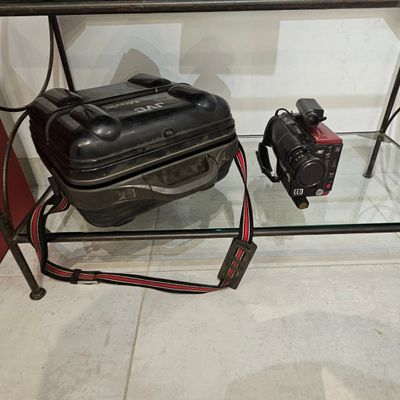 une valise et un appareil photo posés sur une table en verre
