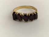 a close up of a gold ring with garnets on it