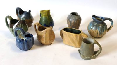 de nombreux vases de styles variés posés sur une surface blanche