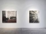 two paintings hanging on the wall in an empty room