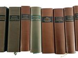 six books are lined up in a row on a white surface