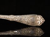 a silver spoon that is sitting on a black surface