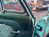 a green truck with a door open on the street