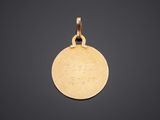 a gold disc pendant with the word, ' love ' on it