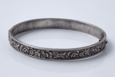 a close up of a silver bracelet on a white surface