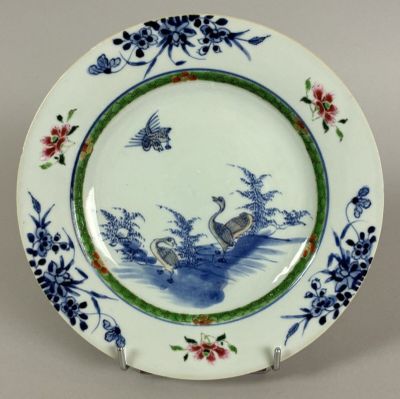 a blue and white plate with a bird and flowers on it