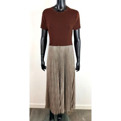 un mannequin vêtu d'une chemise marron et d'une jupe plissée