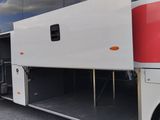a red and white bus parked in a parking lot