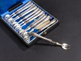 silverware in a case on a black surface with a fork and spoon