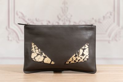 une pochette noire et dorée ornée d'yeux de chat