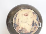 a black and white vase with a brown lid on a white surface