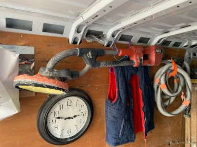 une horloge accrochée au mur à côté d'un tas d'outils