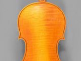an orange violin with a bow on a gray background
