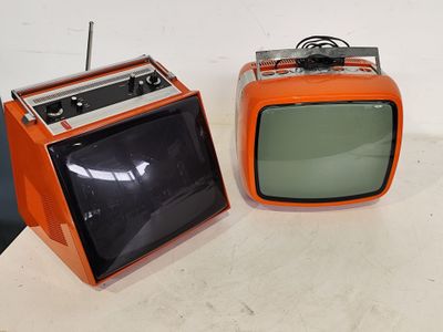 two old televisions sitting on a table next to each other