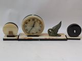 a clock with a bird figurine sitting on top of it