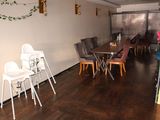 many chairs and a table in a room with wood flooring