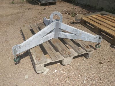 une palette en bois posée par terre à côté d'un objet métallique