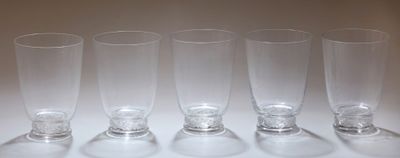 six verres vides sont alignés sur une surface blanche
