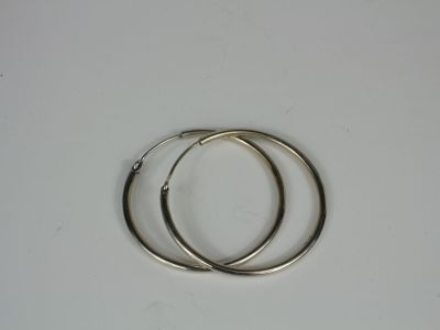 pair of silver hoop earrings on a white surface