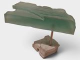 an image of a sculpture of a green umbrella on a rock
