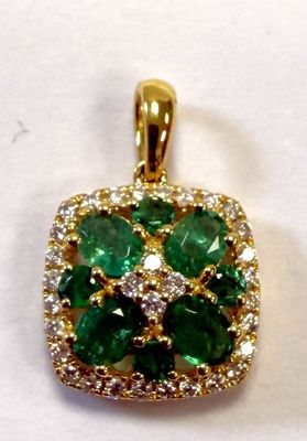 a close up of a green and white diamond pendant on a white surface