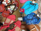 de nombreuses paires de tongs dans une boîte posée par terre