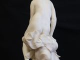 marble statue of a woman sitting on a rock with a dog