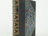 un vieux livre noir aux bords dorés et à la couverture bleue