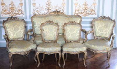 quatre chaises et un canapé dans une pièce dont l'un des murs est tapissé