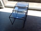 une table en verre avec un plateau en verre, placée devant une fenêtre