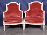 une paire de fauteuils en velours rouge avec des bordures blanches et des pieds en bois