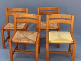 four chairs and a table in a room with a gray wall