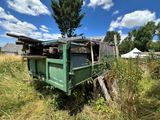 un camion-benne vert garé dans l'herbe