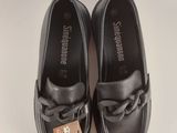 black loafers with a bow on the front and a tag on the side