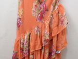 an orange dress hanging on a hanger on a white wall