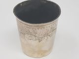 an old silver cup with a black rim on a white background