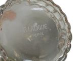 a glass vase with a silver lid on a white surface